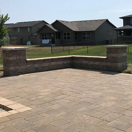 An outdoor area includes stone pavers and a stone wall