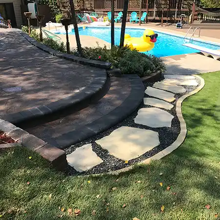 A stone walkway leads up to an outdoor pool area