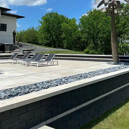 A stone wall surrounds an outdoor seating area