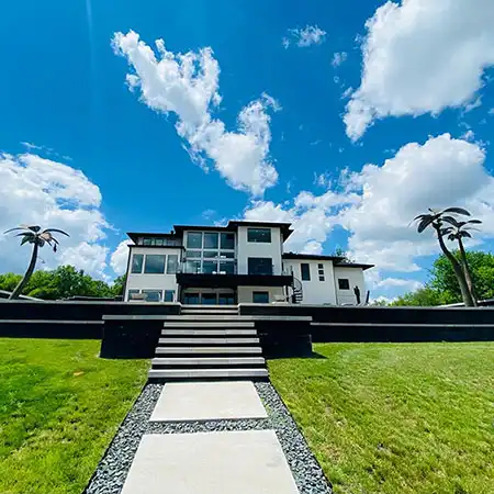 A decorative walkway and staircase leads up to the entrance of a home