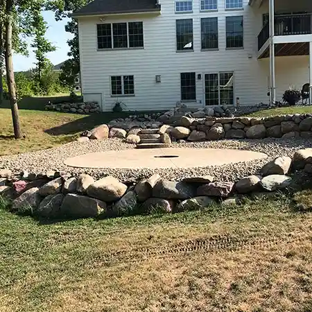 A stone staircase leads down to a paved outdoor space