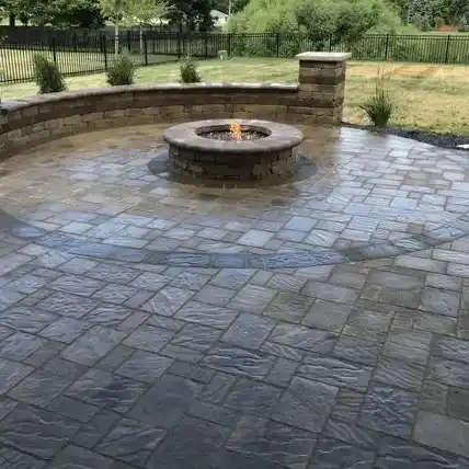 An outdoor fire pit surrounded by patterned stone pavers