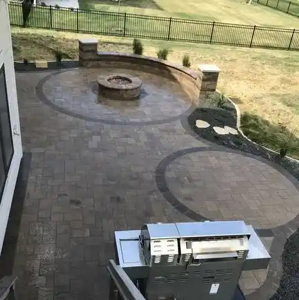 An outdoor fire pit surrounded by patterned stone pavers