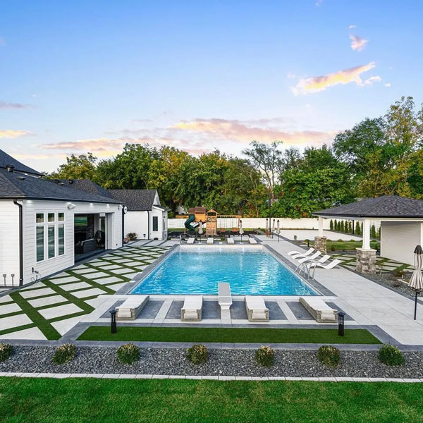 A backyard recreation area includes a pool, lounge area, and playground