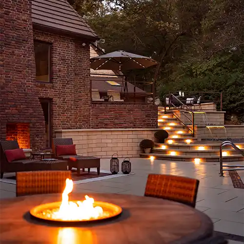 A multi-level outdoor seating area featuring chairs, tables, and fireplaces
