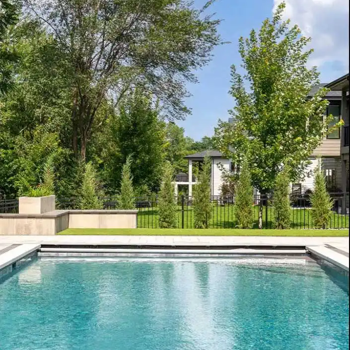 An outdoor pool in a fenced-in backyard